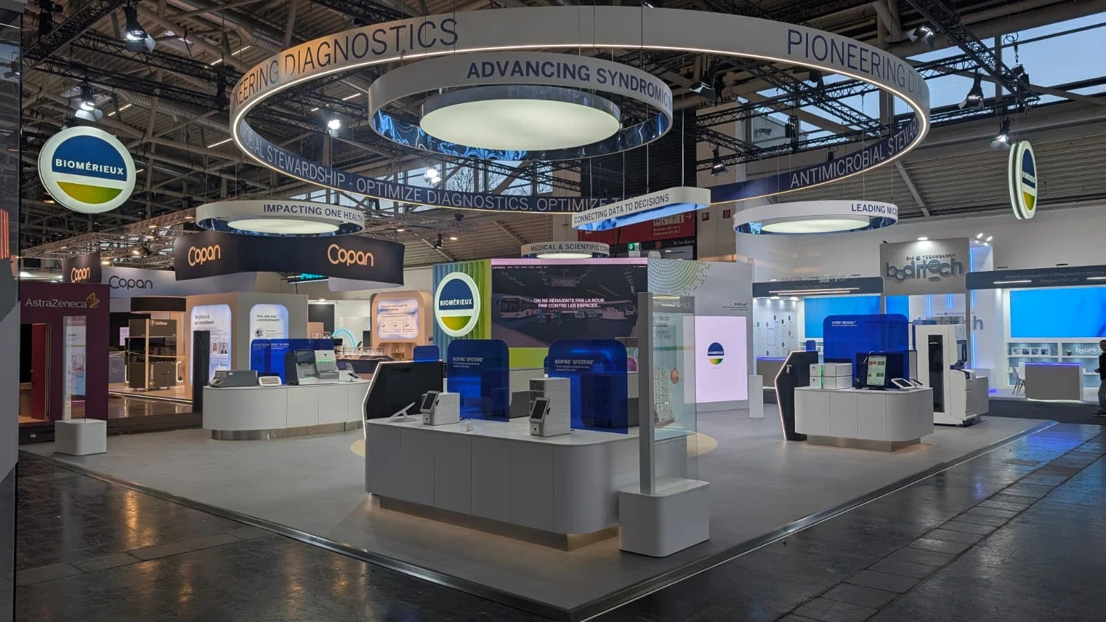 Stand bioMérieux conçu et réalisé par Expace pour le congrès ESCMID Global 2026 à Munich – stand sur-mesure de diagnostic médical avec anneaux lumineux, comptoirs d'accueil et espaces de démonstration.