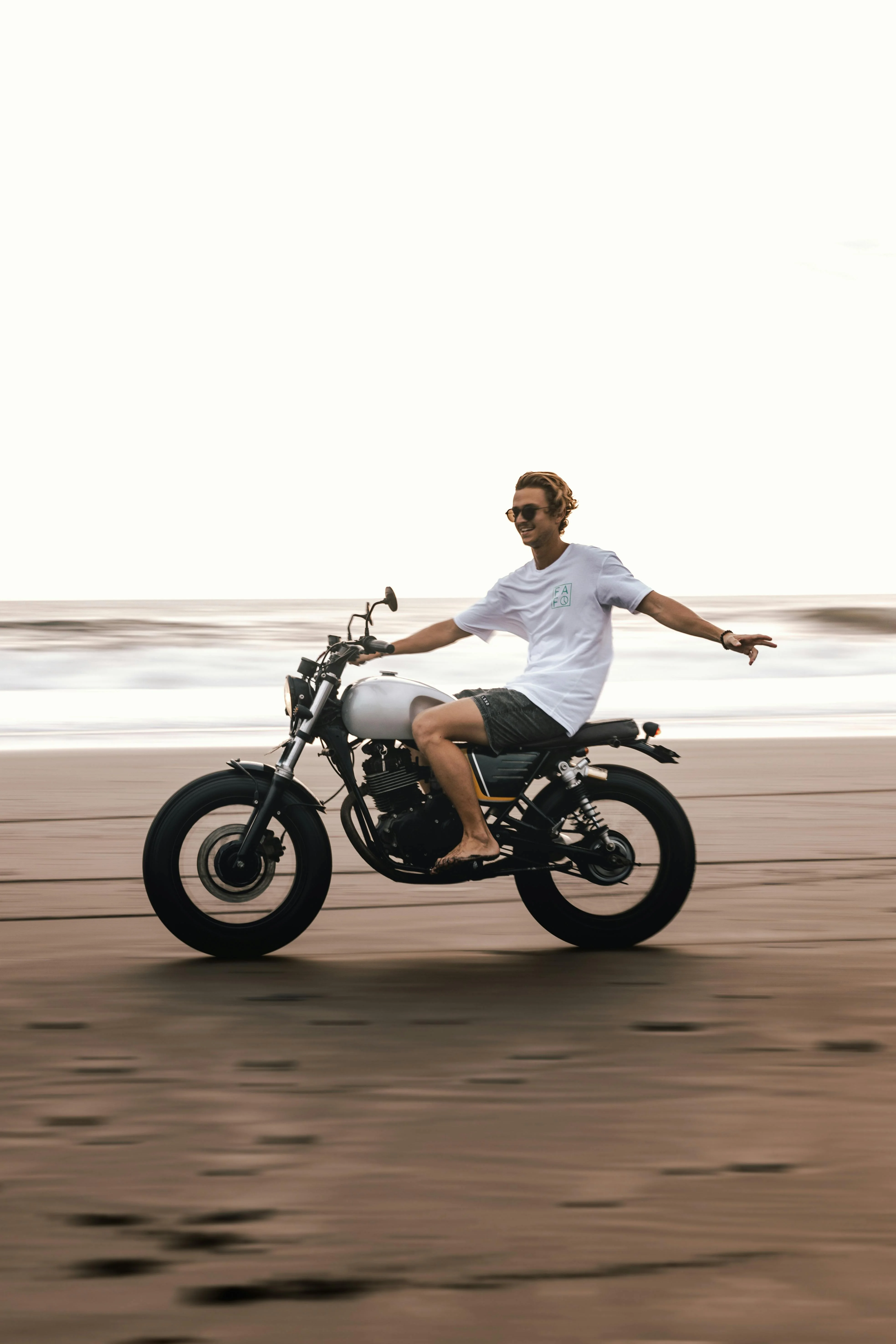 Un motard profitant de la liberté en bord de mer, image parfaite de l’esprit d’aventure et du plaisir de conduire un 2 roues.