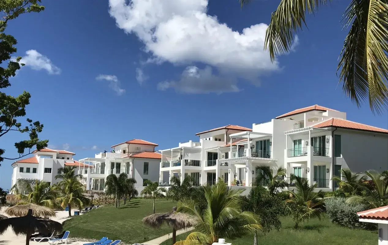 Exterior view of finished multi-level beachfront villas at Windjammer Landing Resort, St. Lucia, with white stucco facades, terracotta tile roofs, and private terraces.