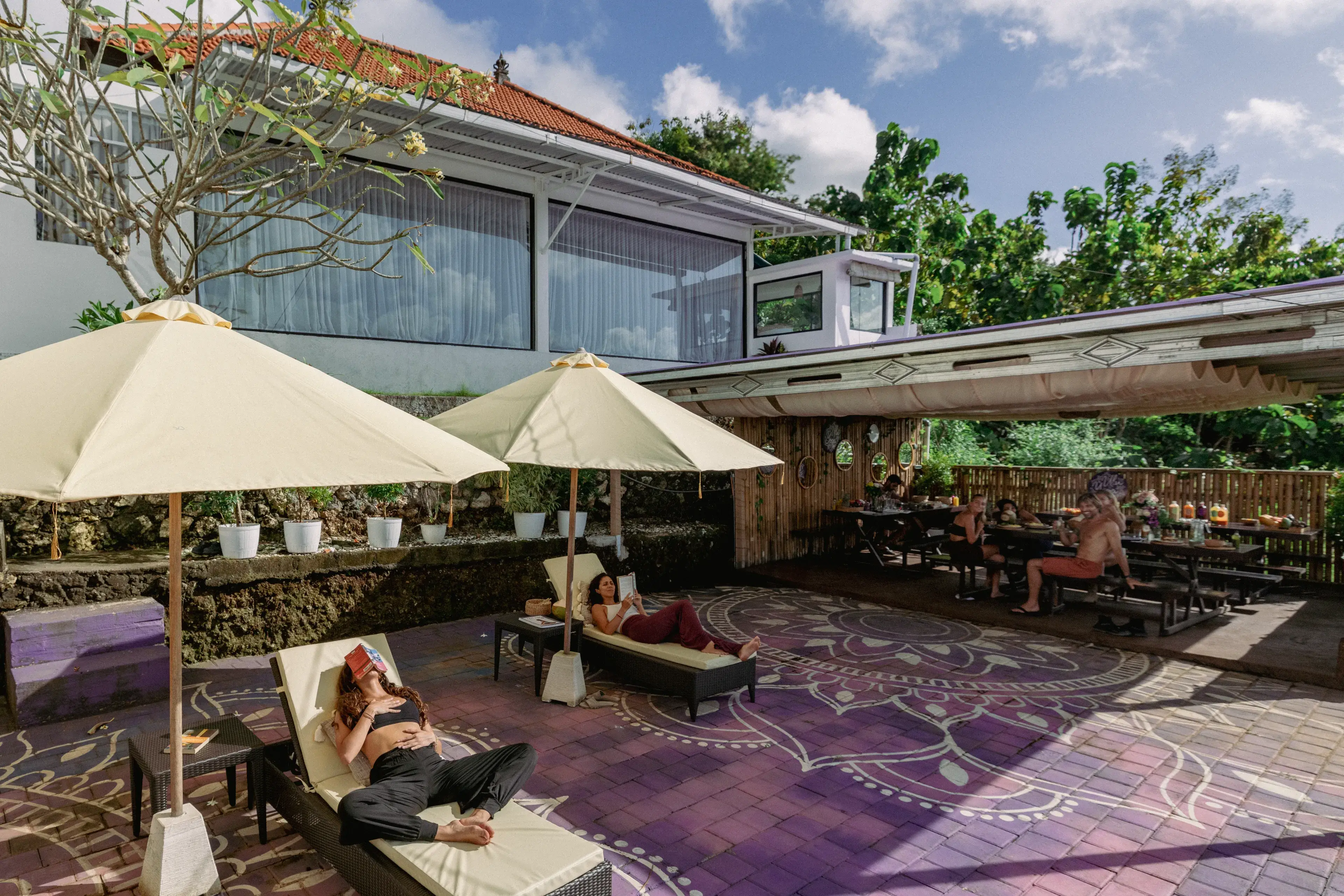 Yoga students relaxing and reading in the mandala courtyard during free time at the 200-hour Bali YTT campus