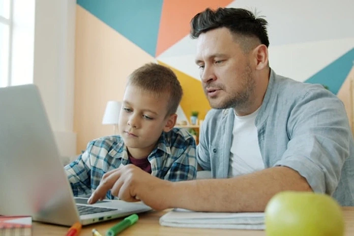 Father and son learning together on a laptop.