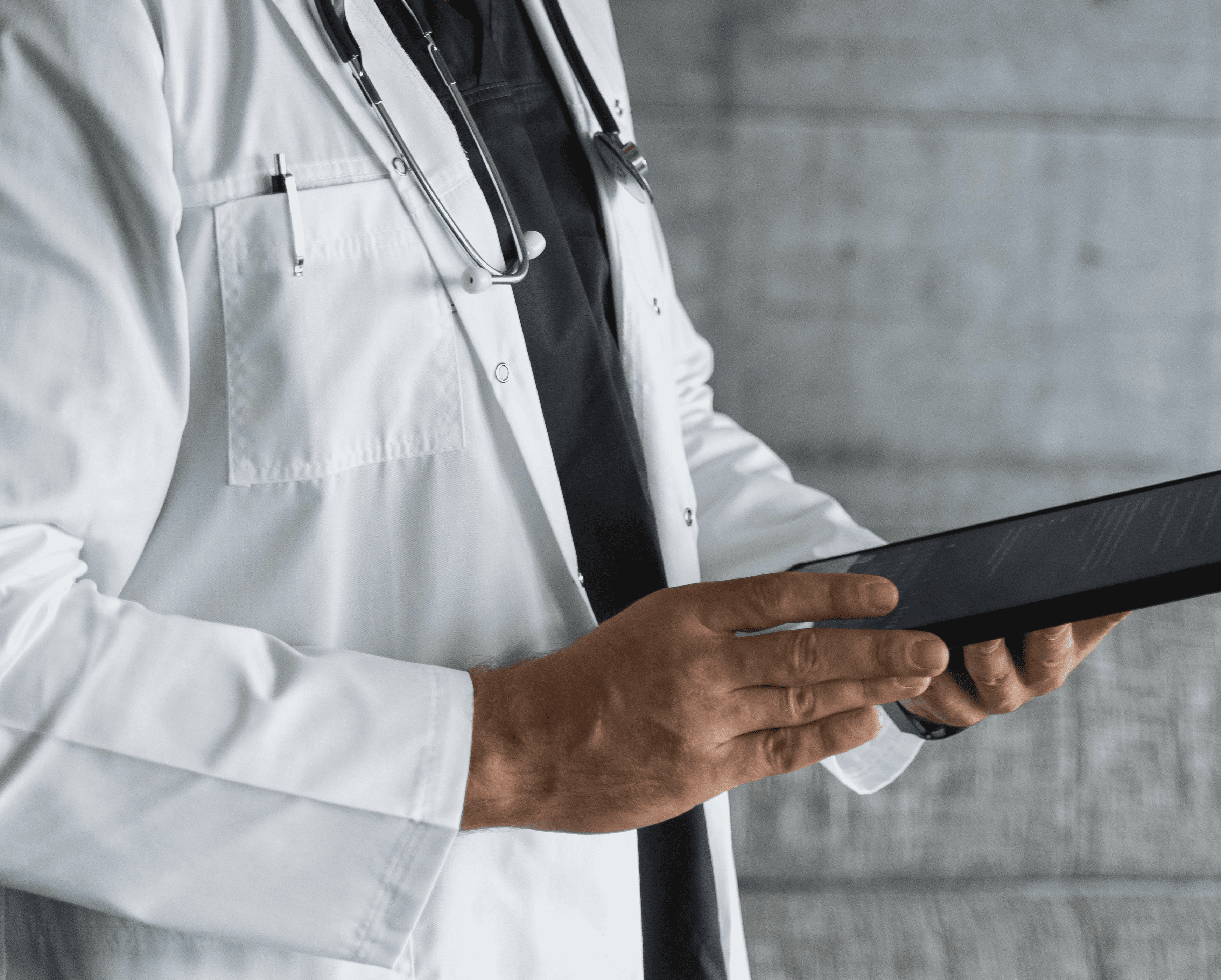 A smiling woman doctor is sitting at her desk and looking at a computer screen showing a medical screening test.