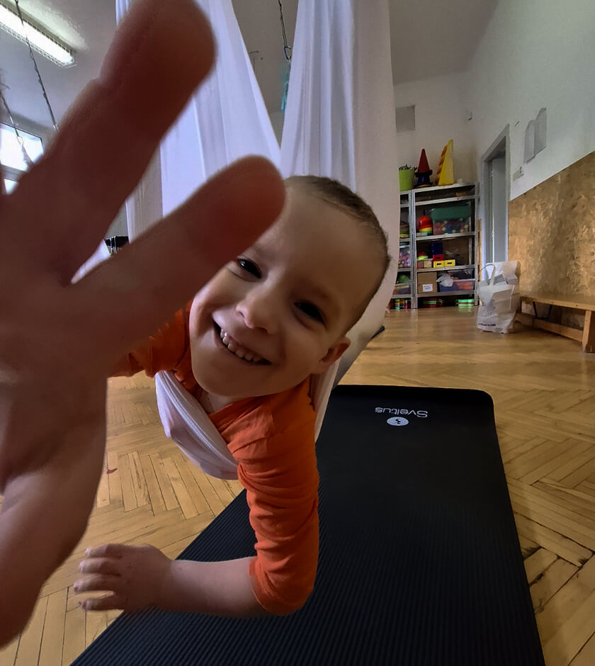 Usměvavý chlapec v herně focený z dynamického podhledu