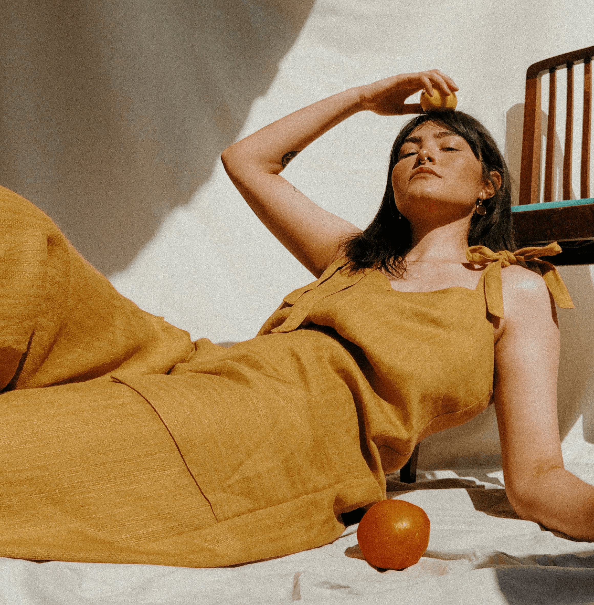 woman in brown sleeveless dress lying on bed
