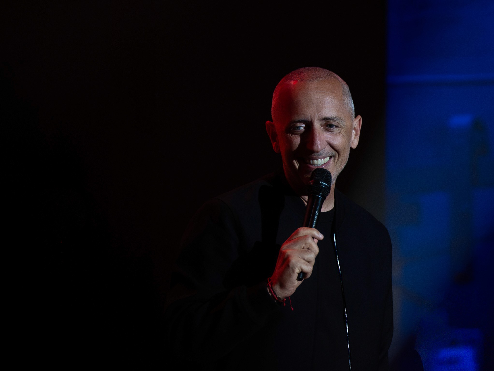 A man with long hair is working on a computer.