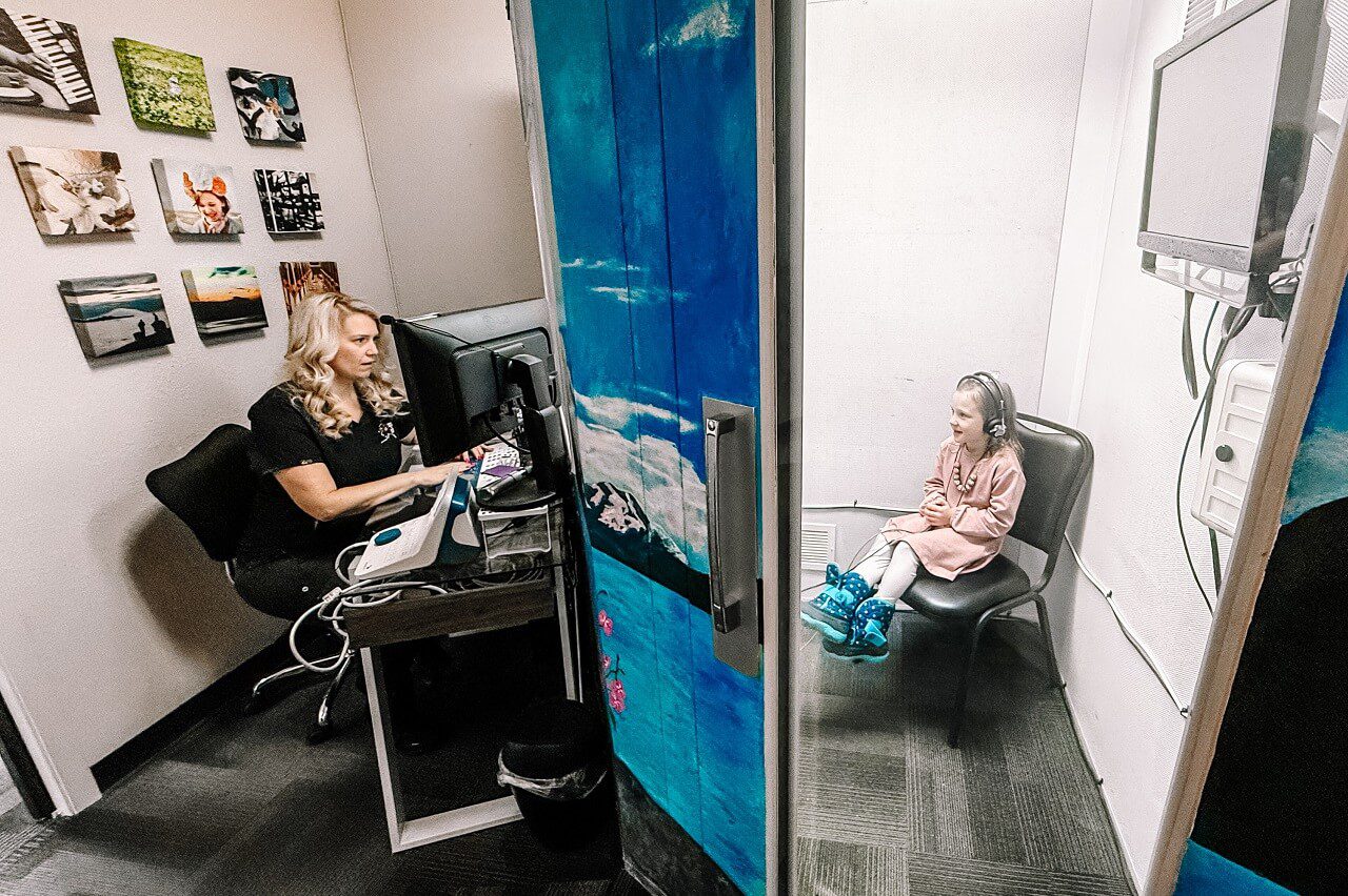 A close-up of a person receiving an ear cleaning, with hands gently handling their ear.