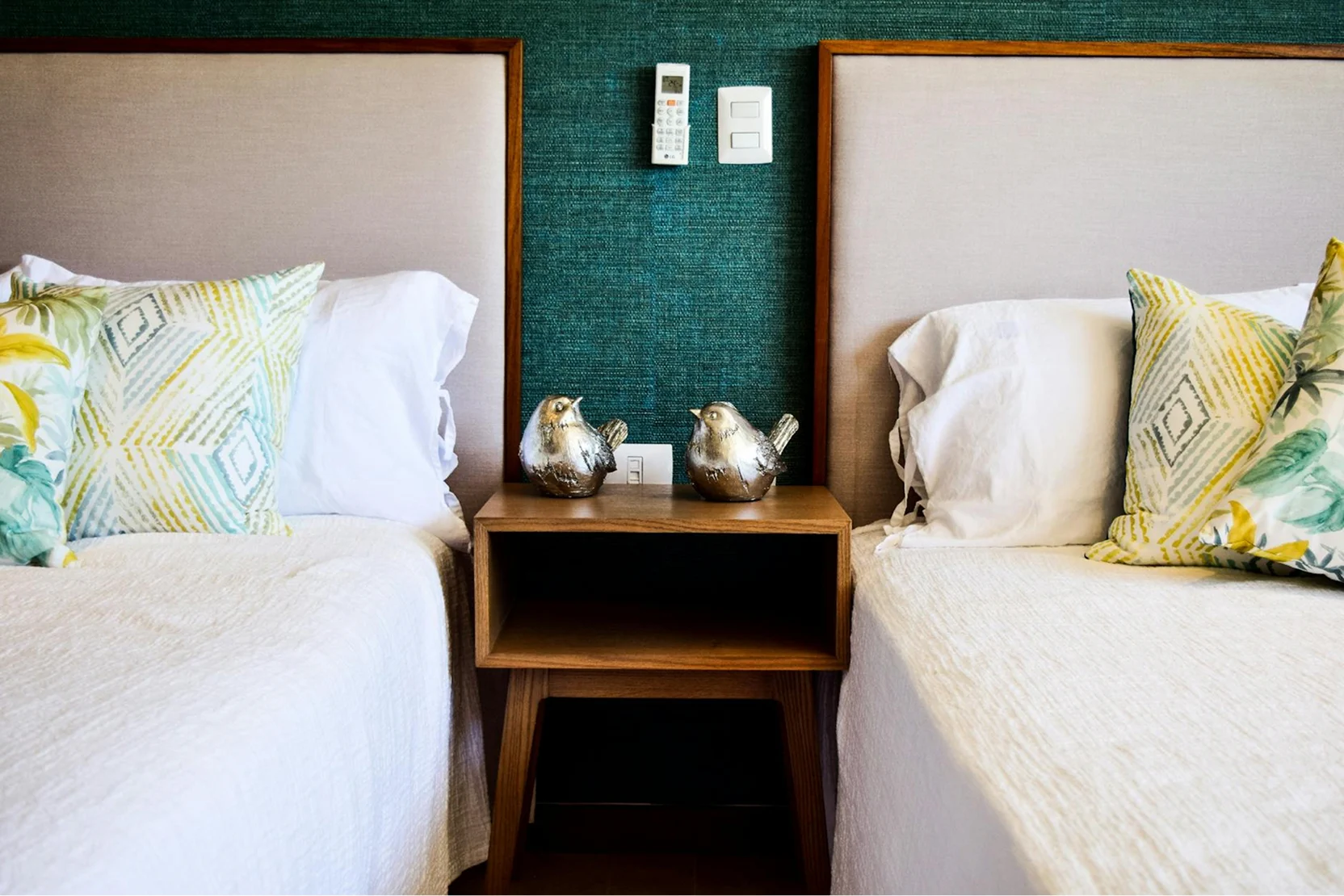 Close-up of two single beds in the garden triple room with a bedside table between them.