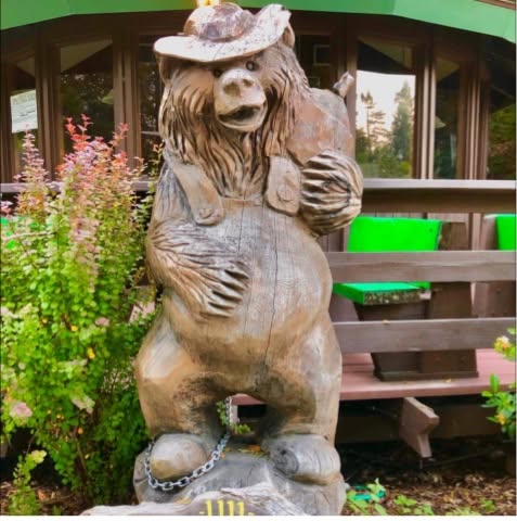 A carved wooden bear outside Chimney Tree Grill.
