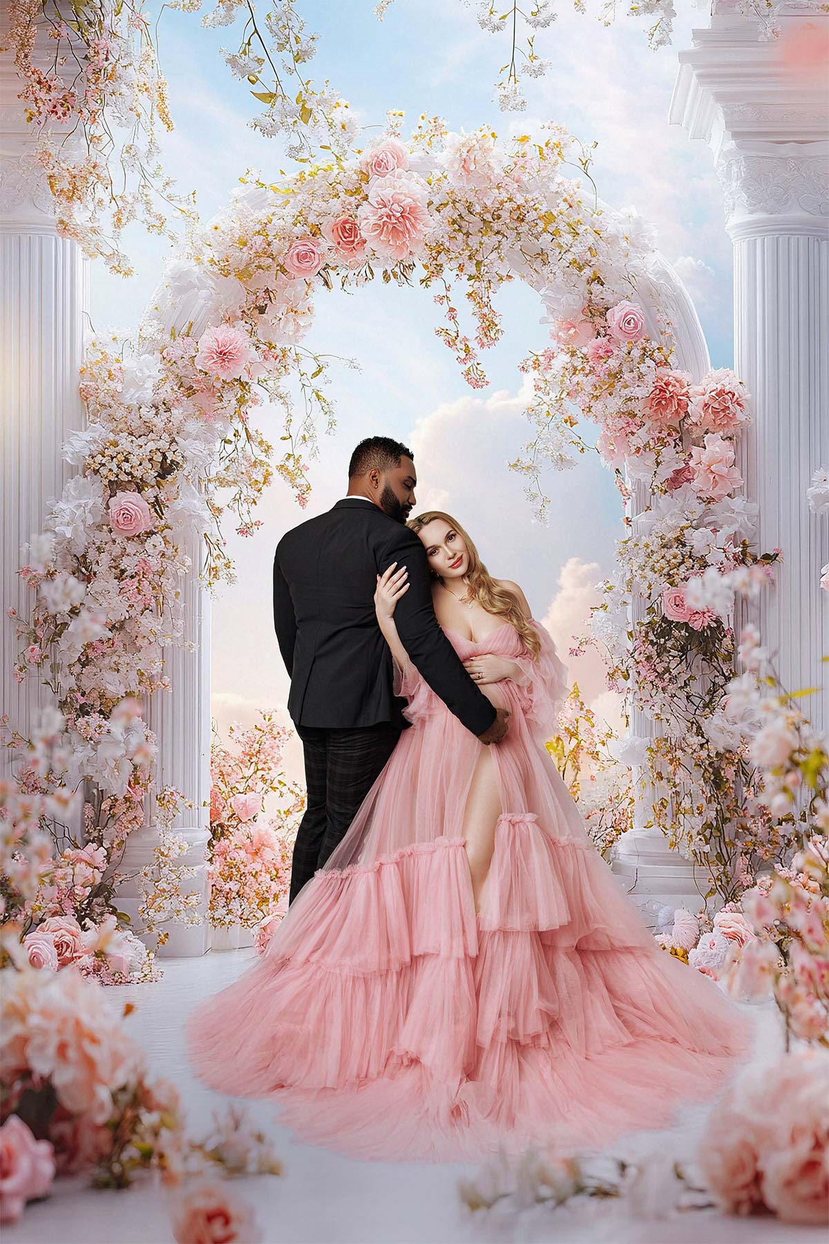 Maternity couple photoshoot — husband gently holds his pregnant wife in studio.