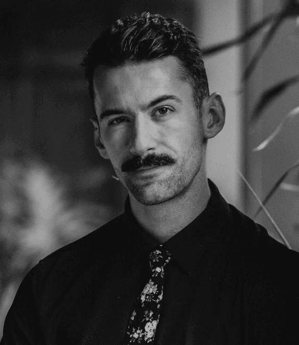 Portrait of a person in dark clothing speaking on a phone