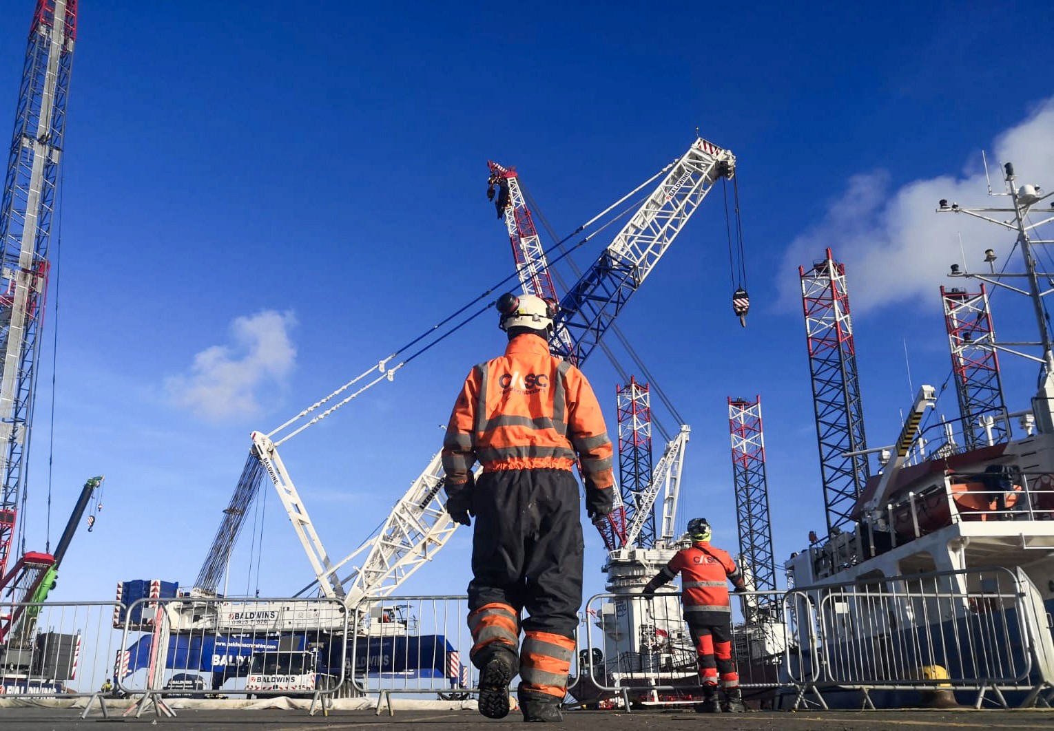 Rigger working beside multiple cranes during offshore wind mobilisation