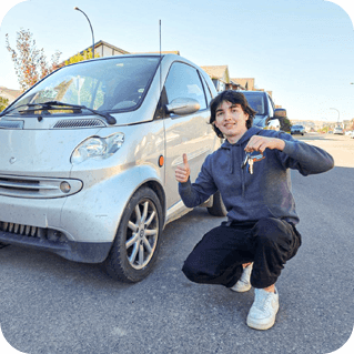 CarKeyAction locksmith holding newly programmed Smart Fortwo keys beside the vehicle