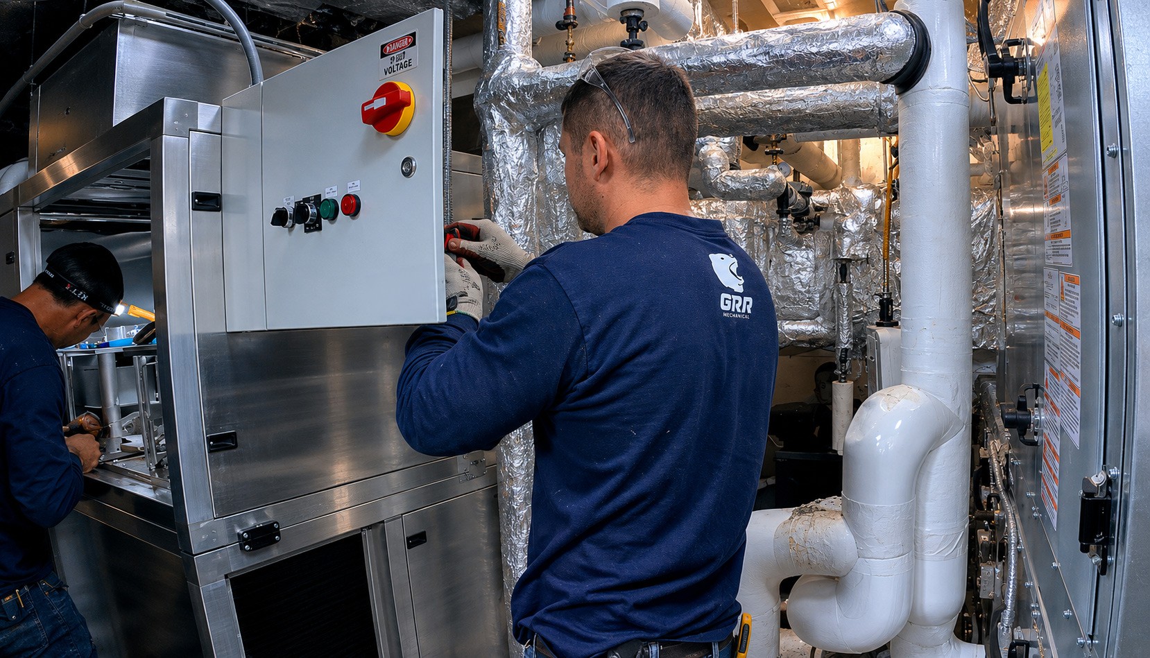 GRR technician working on HVAC control panel in NYC mechanical room after retrofit installation