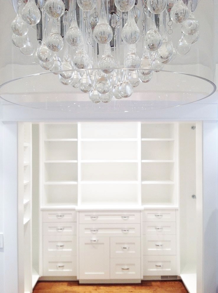 Image of Luxury primary ensuites feature custom closet design with crystal chandelier and spacious shelving by KHD Homes.