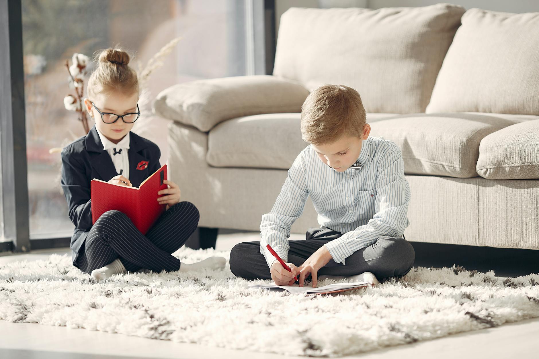 A mother and two children sitting on a cozy sofa reading living books together during a peaceful morning session.