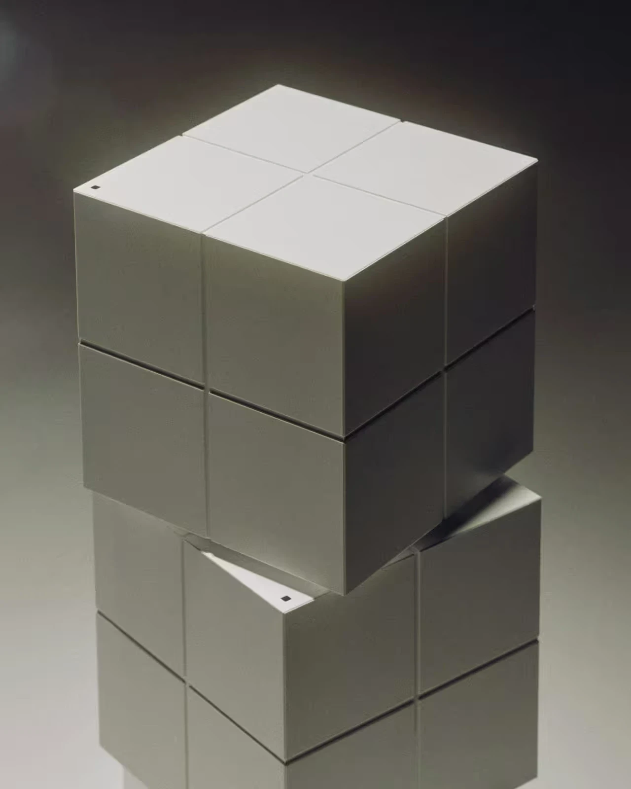 Two stacked white modular cube sculptures photographed against a grey gradient background.