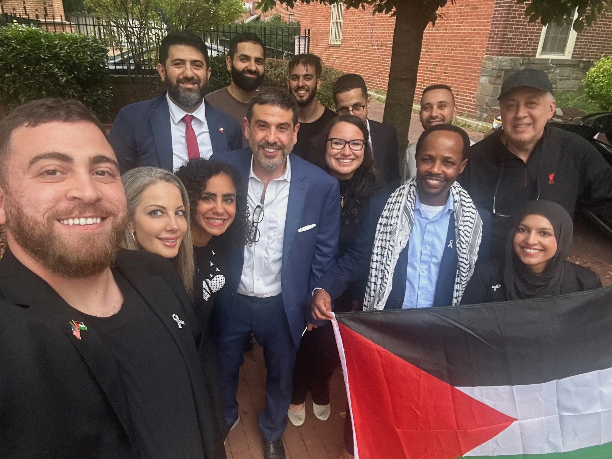 Dr. Hamawy with volunteers and community members holding a Palestinian flag at a local campaign event in New Jersey District 12