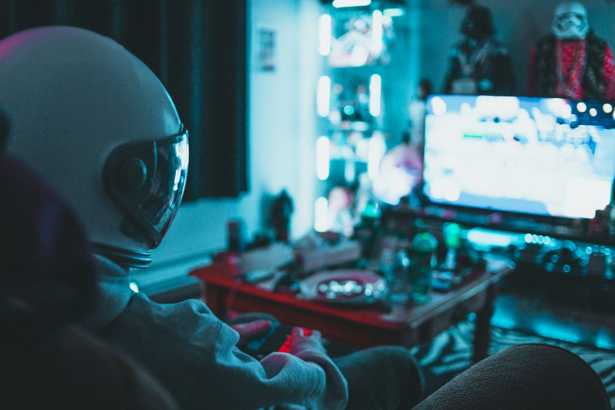 Person in a helmet watching television with headphones and lights.
