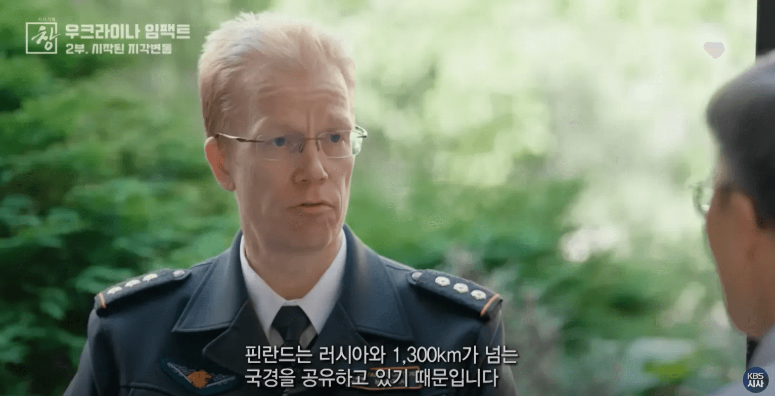 핀란드 국경수비대 나폴라 사령관이 인터뷰하는 모습이다. 안경을 쓴 금발의 사령관이 군복을 입고 야외에서 인터뷰 중이며, 자막으로 "핀란드는 러시아와 1,300km가 넘는 국경을 공유하고 있기 때문입니다"라는 내용이 표시되어 있다.