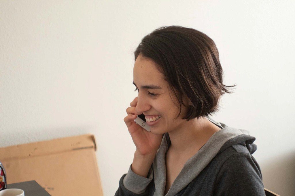 Smiling woman speaking on the phone to request support