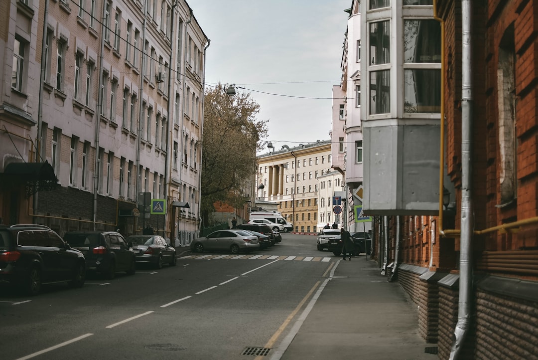 cars parked on side of the road near buildings during daytime
