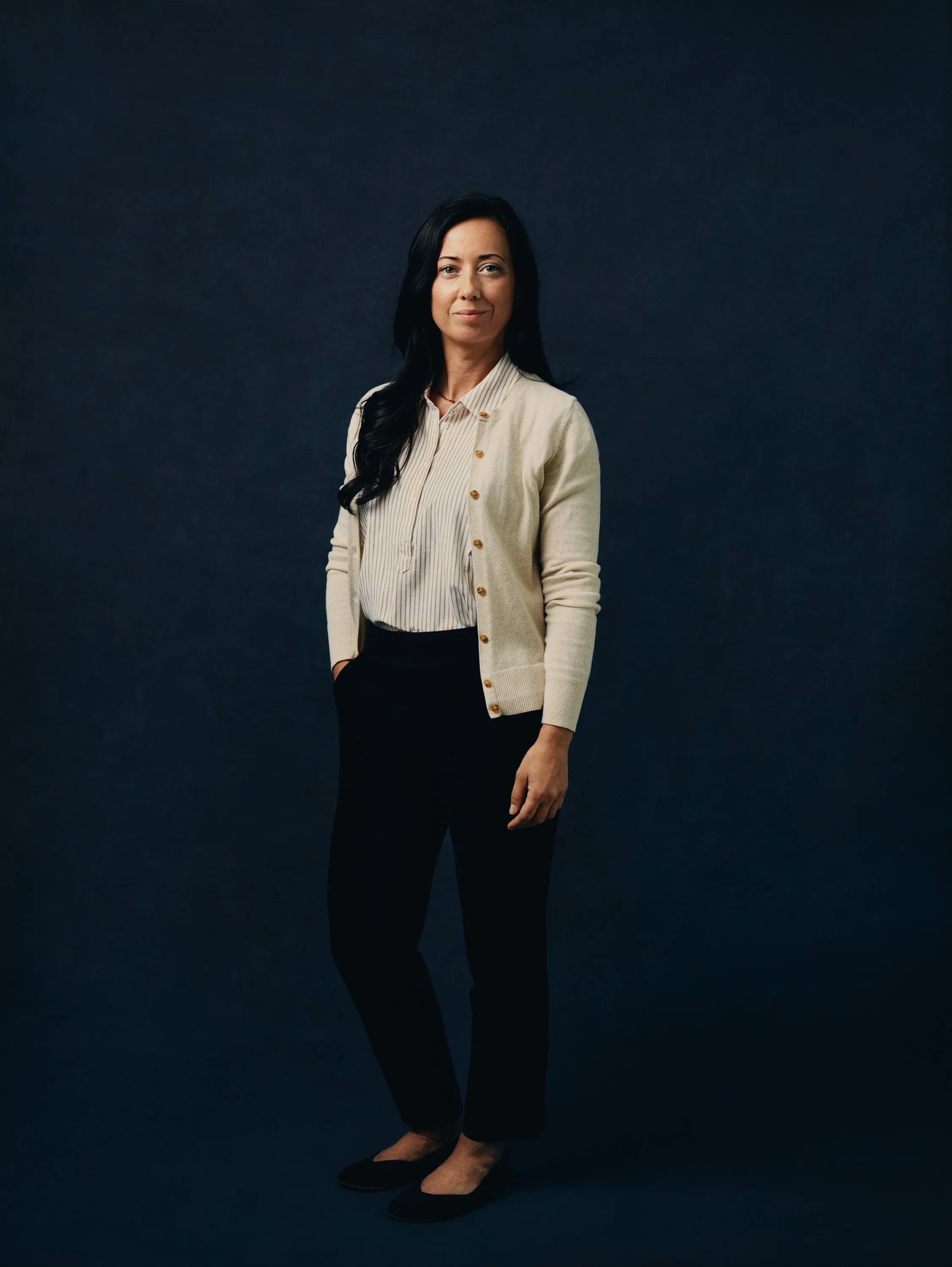 smiling woman standing while holding orange folder