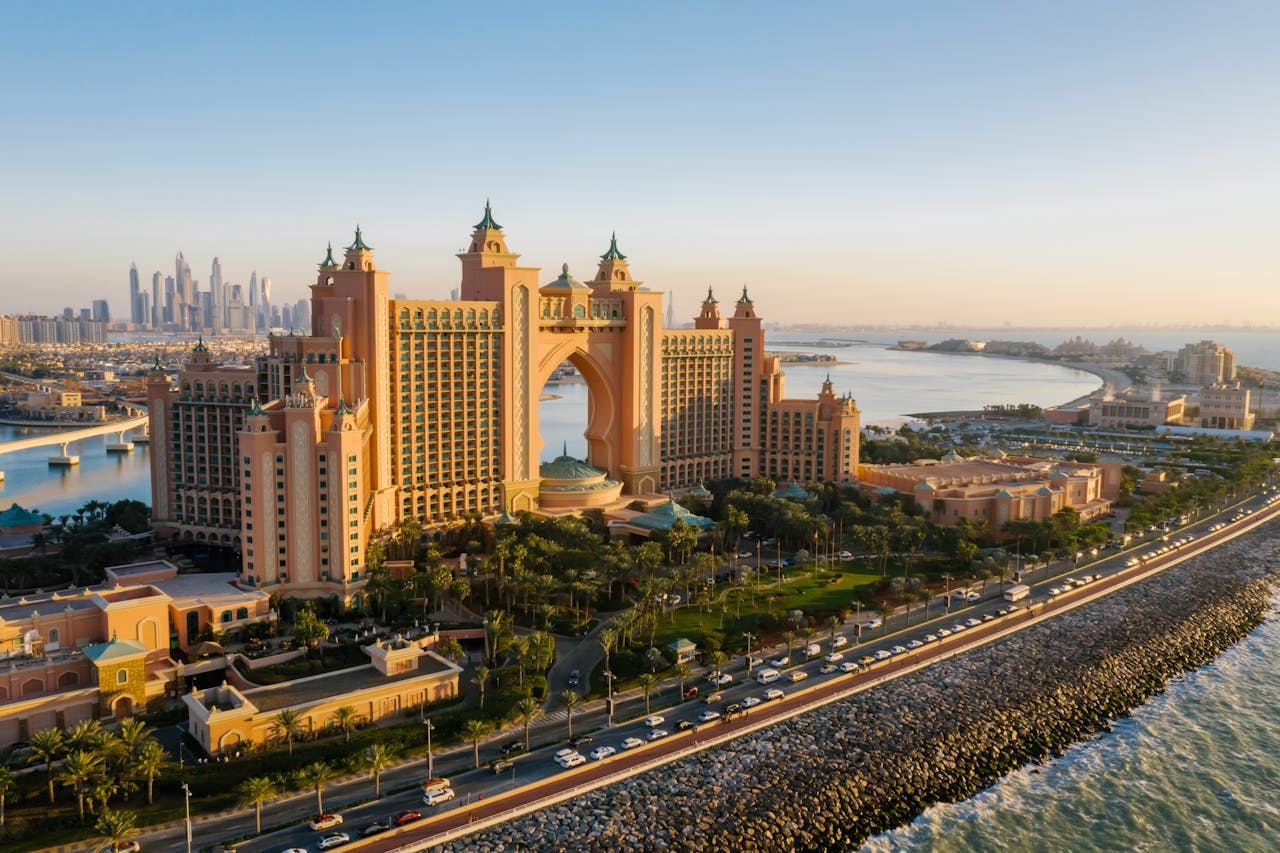 The Atlantis The Palm in Dubai at an aerial view, featuring the roads, palm trees, and the resort itself.