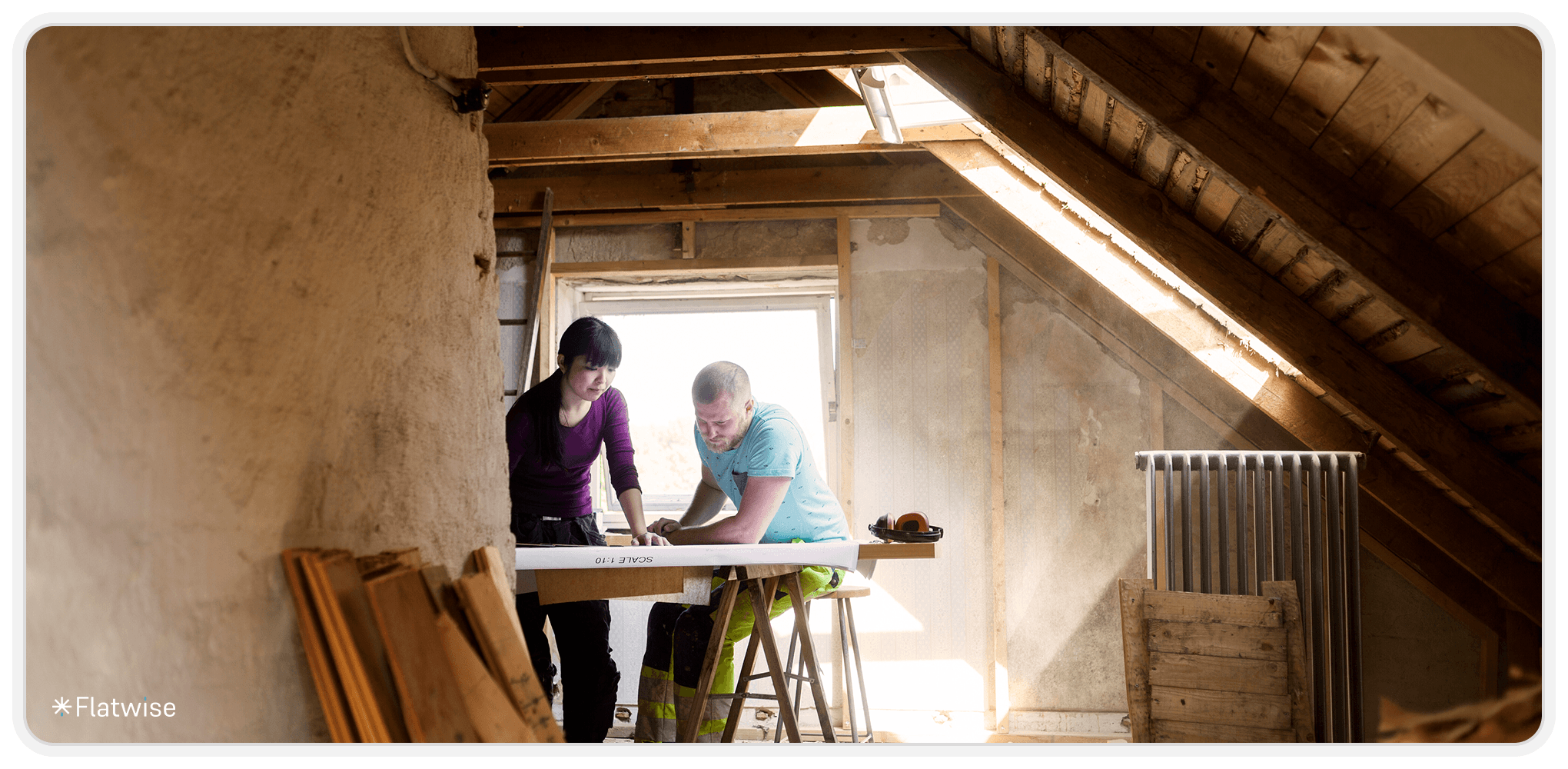 Zwei Personen, die an einer Werkbank in einem Dachgeschoss arbeiten.