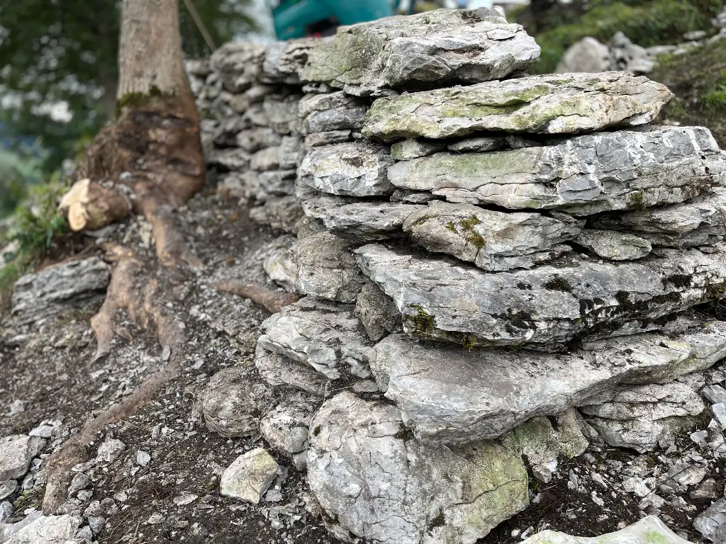 Alternativen zu Trockenmauern Bagger hebt Steine