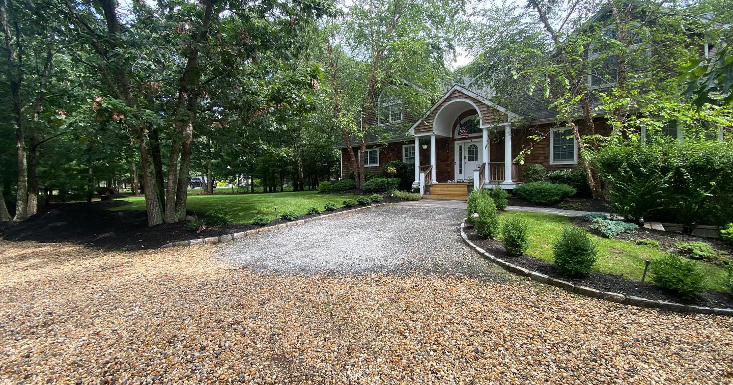 Gravel drive and landscaped beds framing a home entry, Nassau County