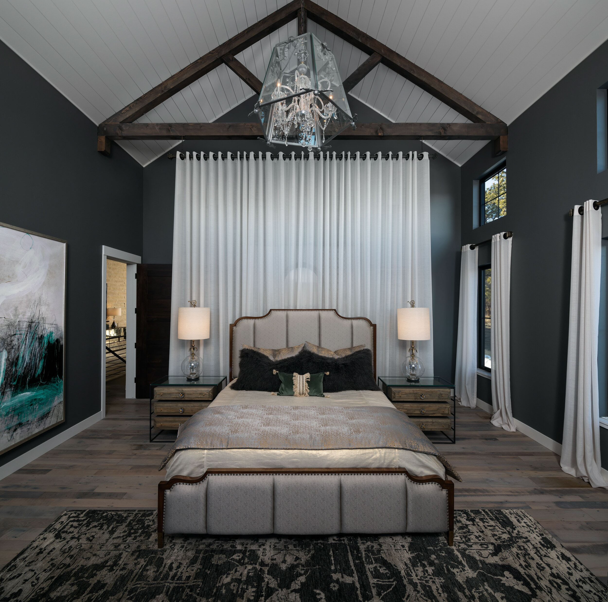 Bedroom with vaulted ceiling, chandelier and abstract art