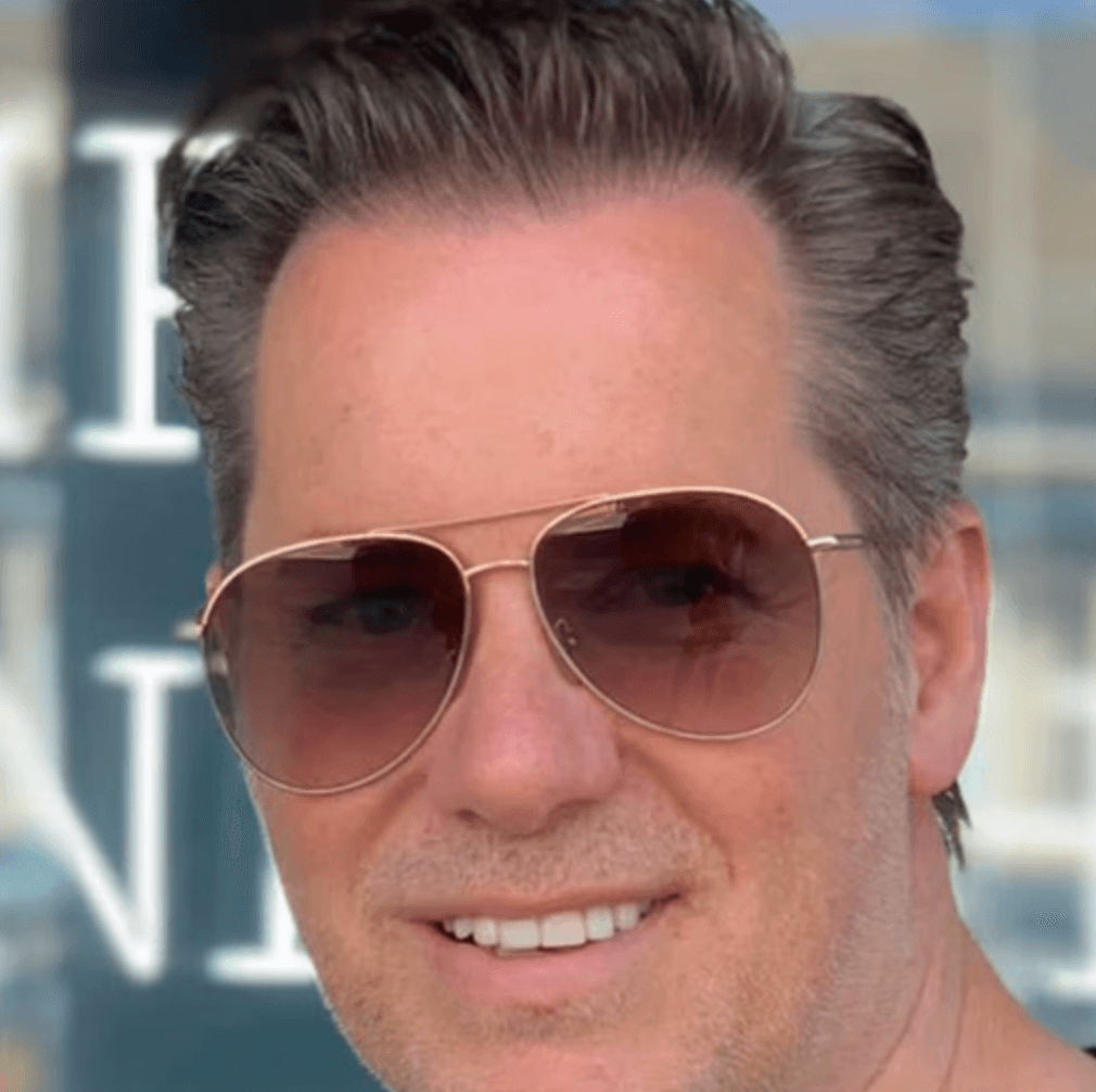 A person in a white shirt black coat with the fair skin looking infront