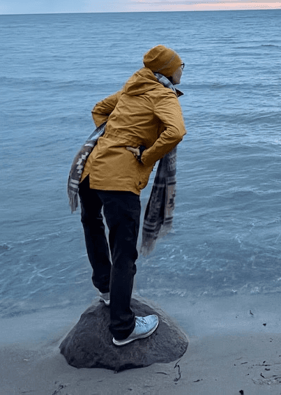 Close-up of a dark green leaf showing its textured surface and central vein against a muted background.
