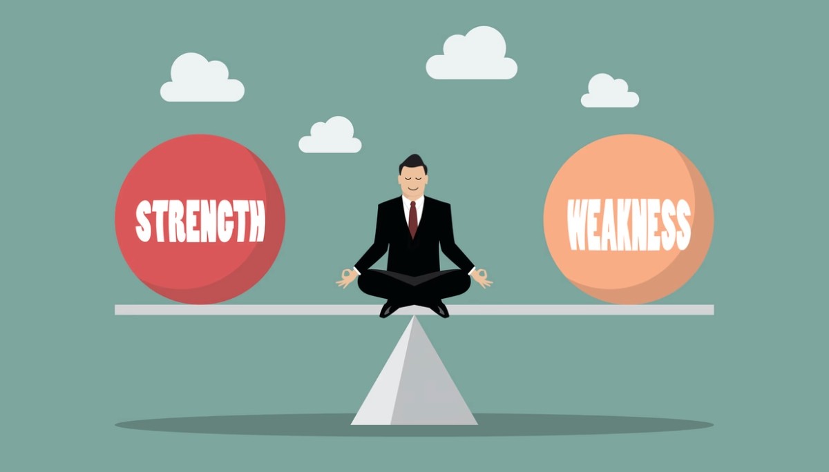 Man meditating on a balanced seesaw between spheres labeled “Strength” and “Weakness”.