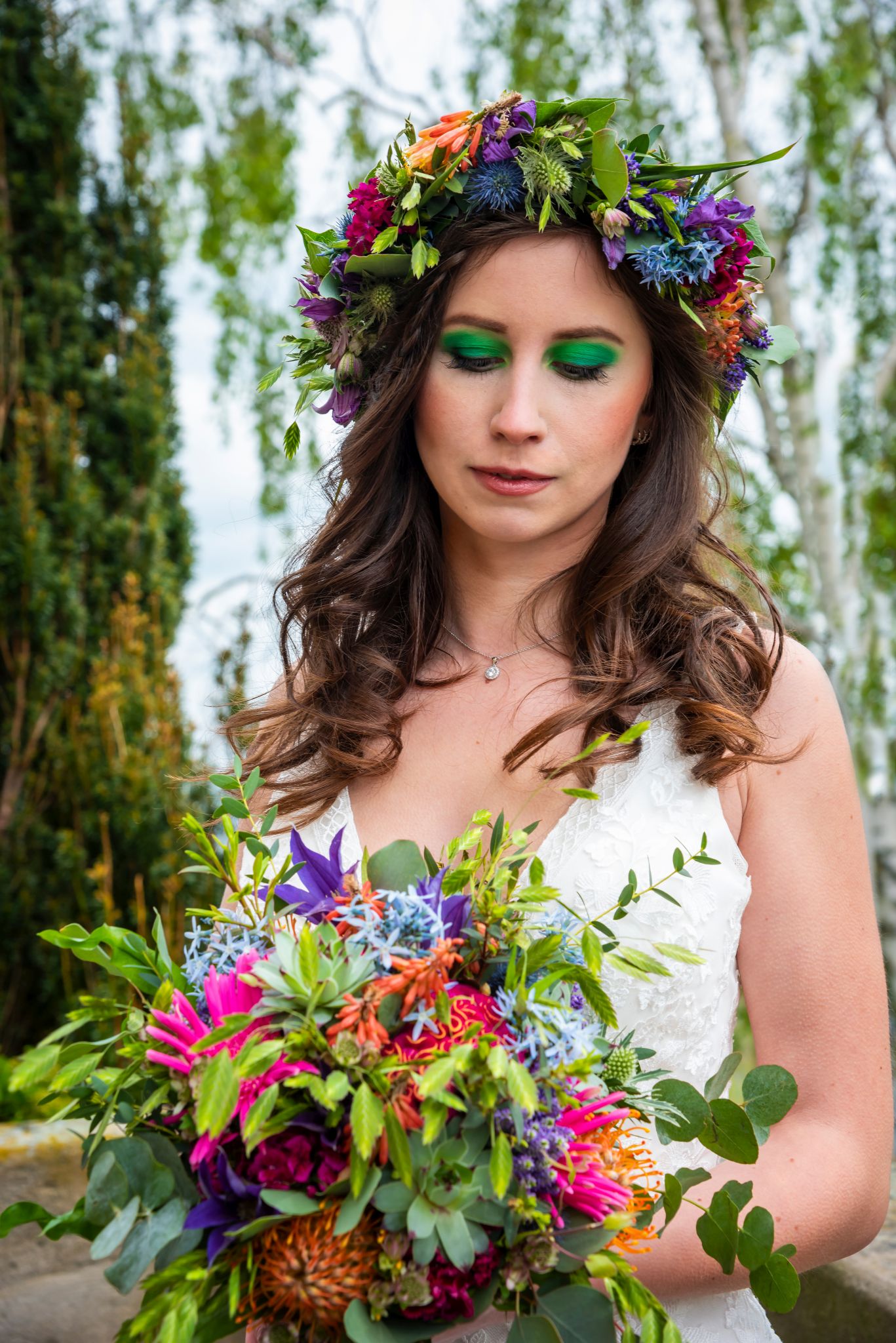 Romantische Braut hält einen Brautstrauß aus roten Amaryllis und Efeu, perfekt für eine winterliche Hochzeit.