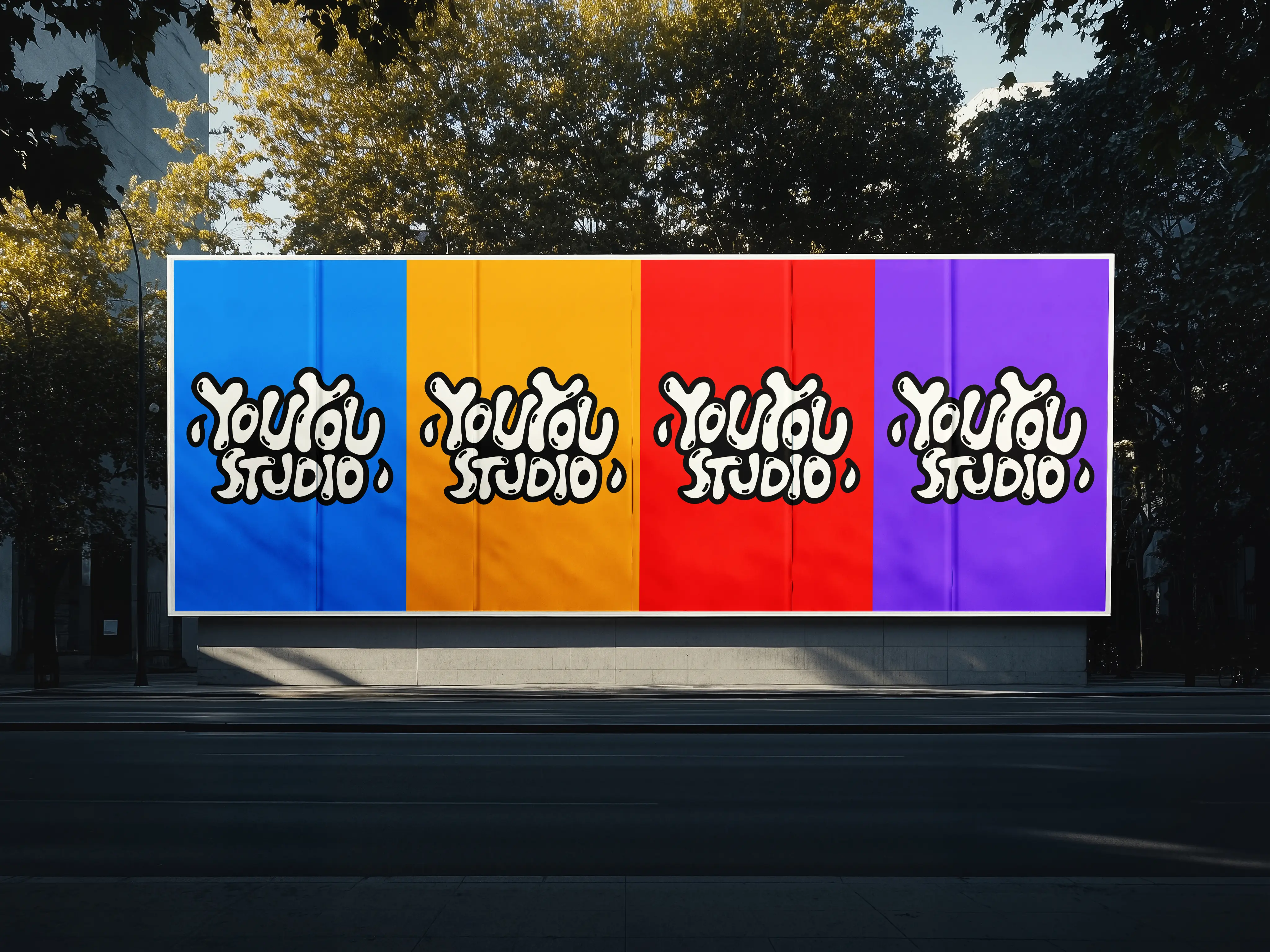 Mockup affichage publicitaire extérieur Youyou Studio avec logo décliné en quatre couleurs : bleu, orange, rouge et violet