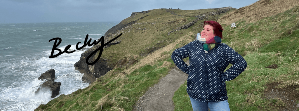 Image of Becky James, illustrator from Inky Thinking standing on coastal path
