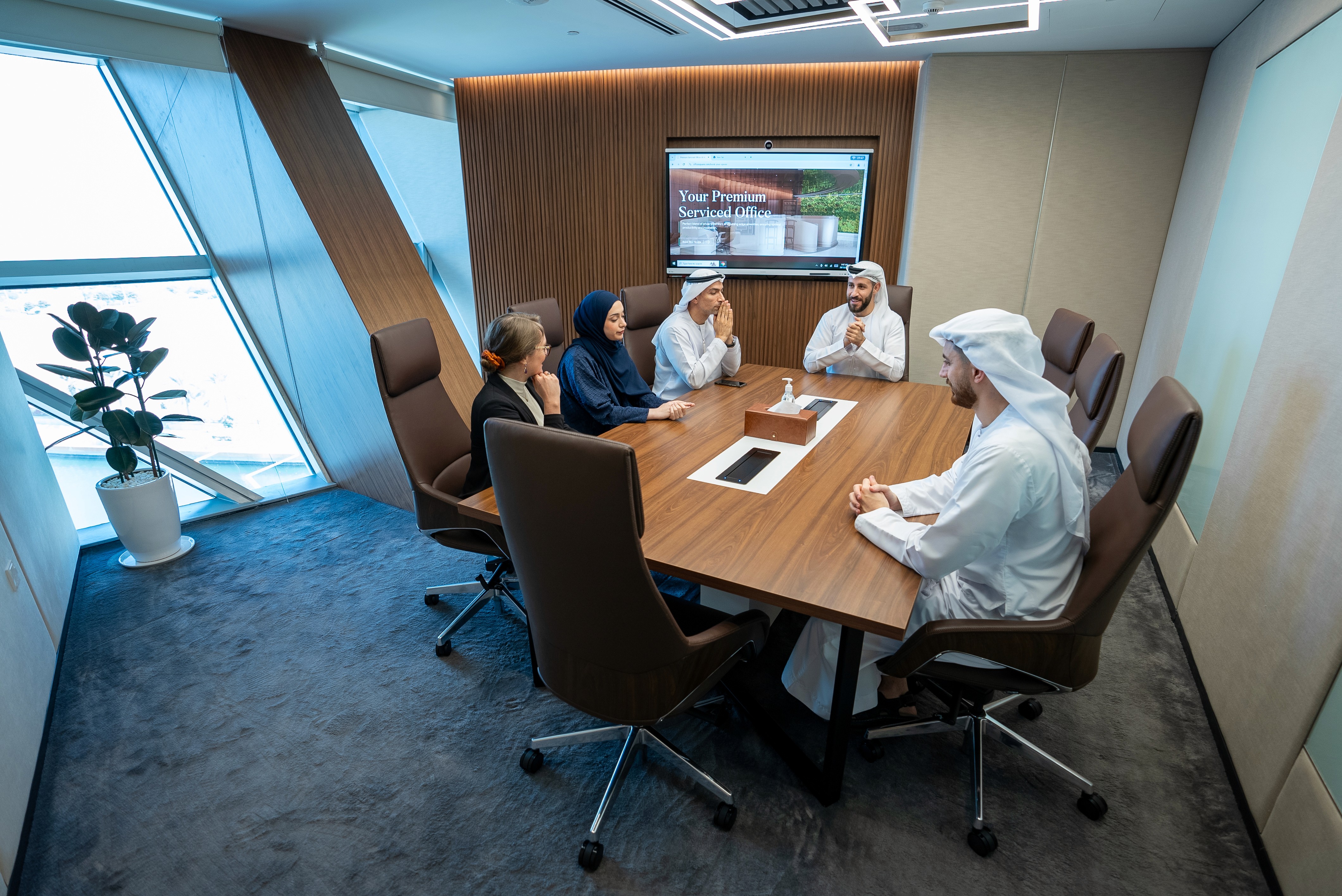 Coworking space at Aldar HQ with natural daylight, waterfront views, and executive desk setups.