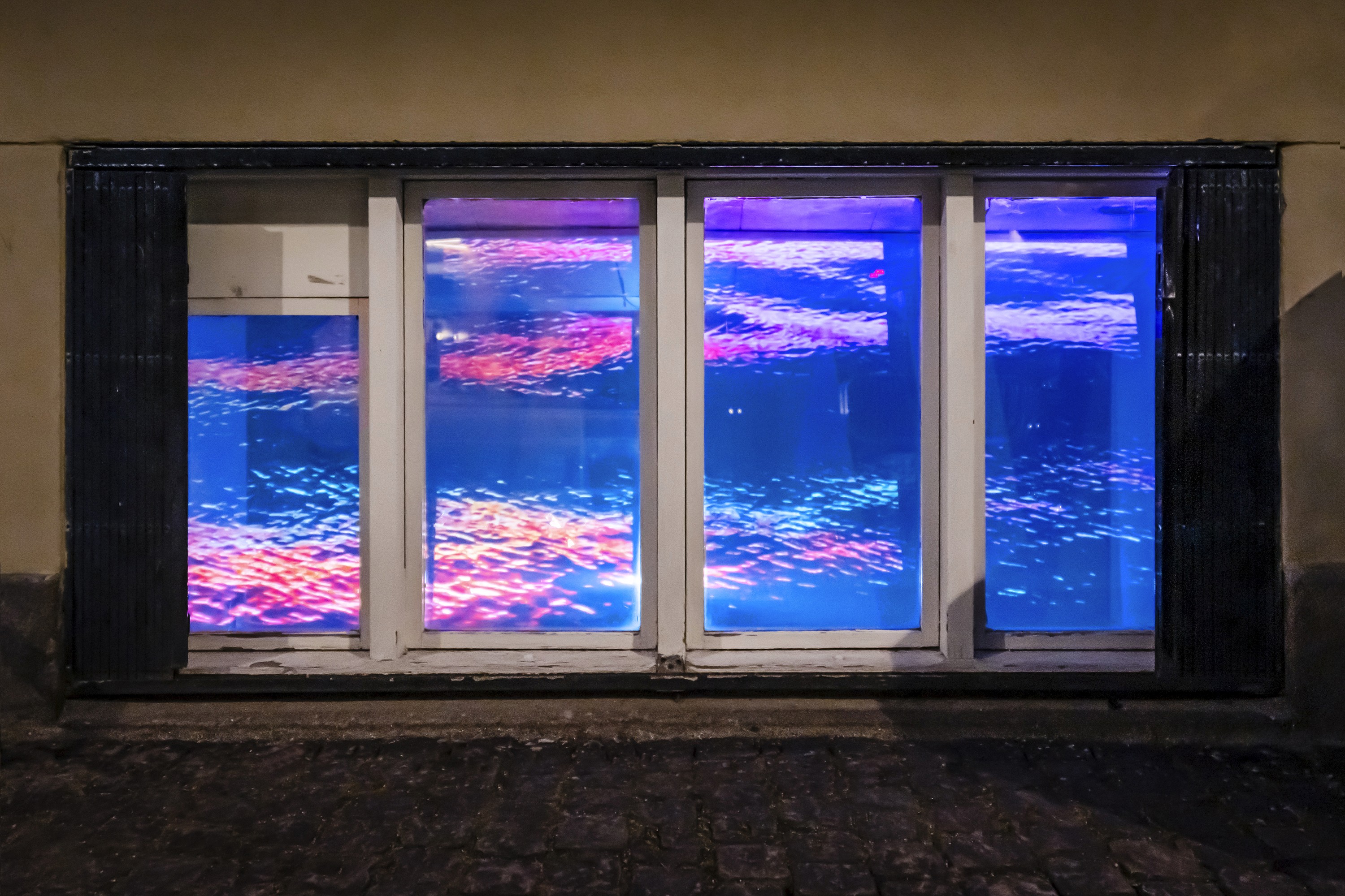 A window viewed from outside, with a colorful pattern on the glass