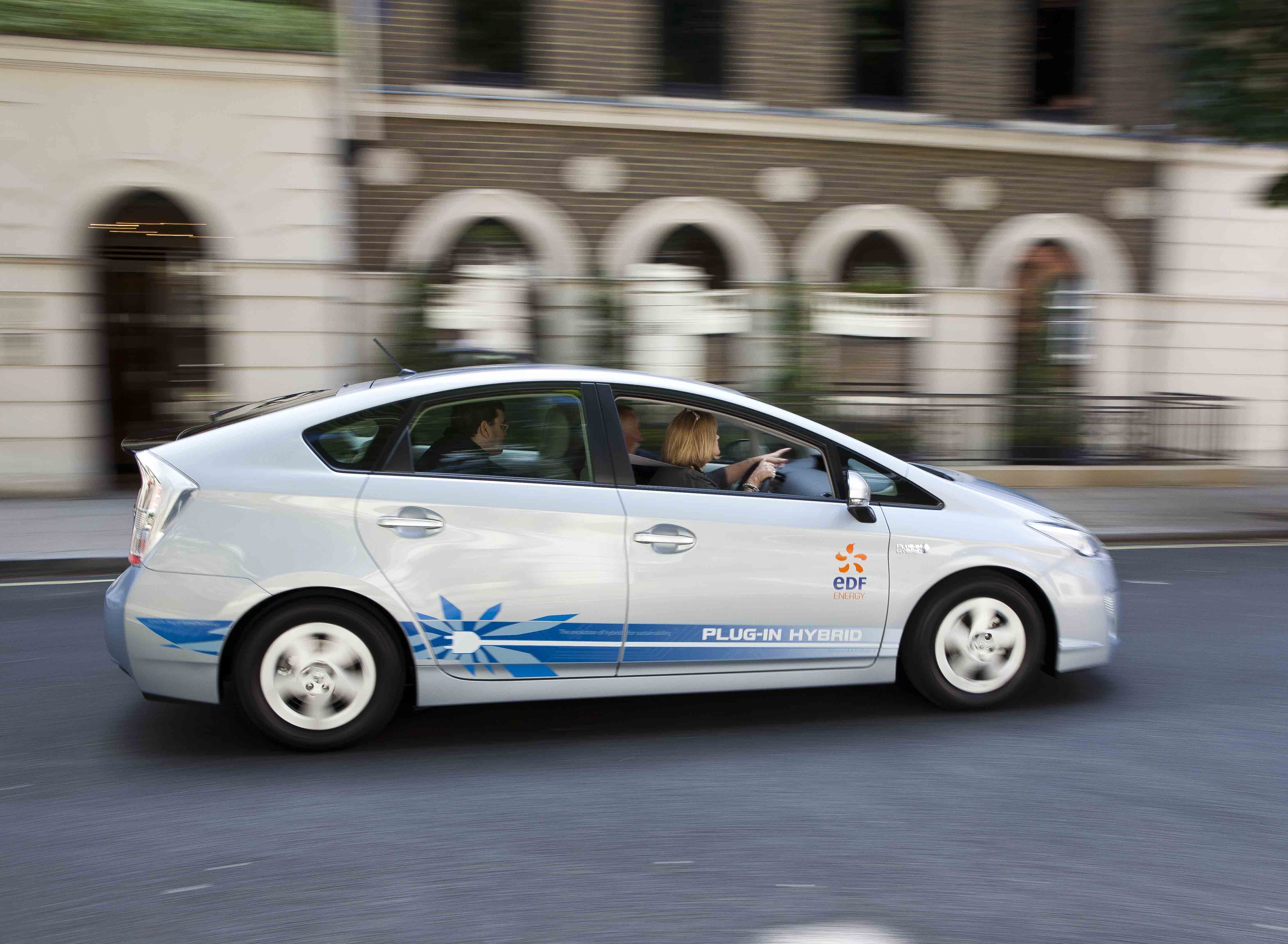 White Toyota Prius driving through a city street during an automotive press launch