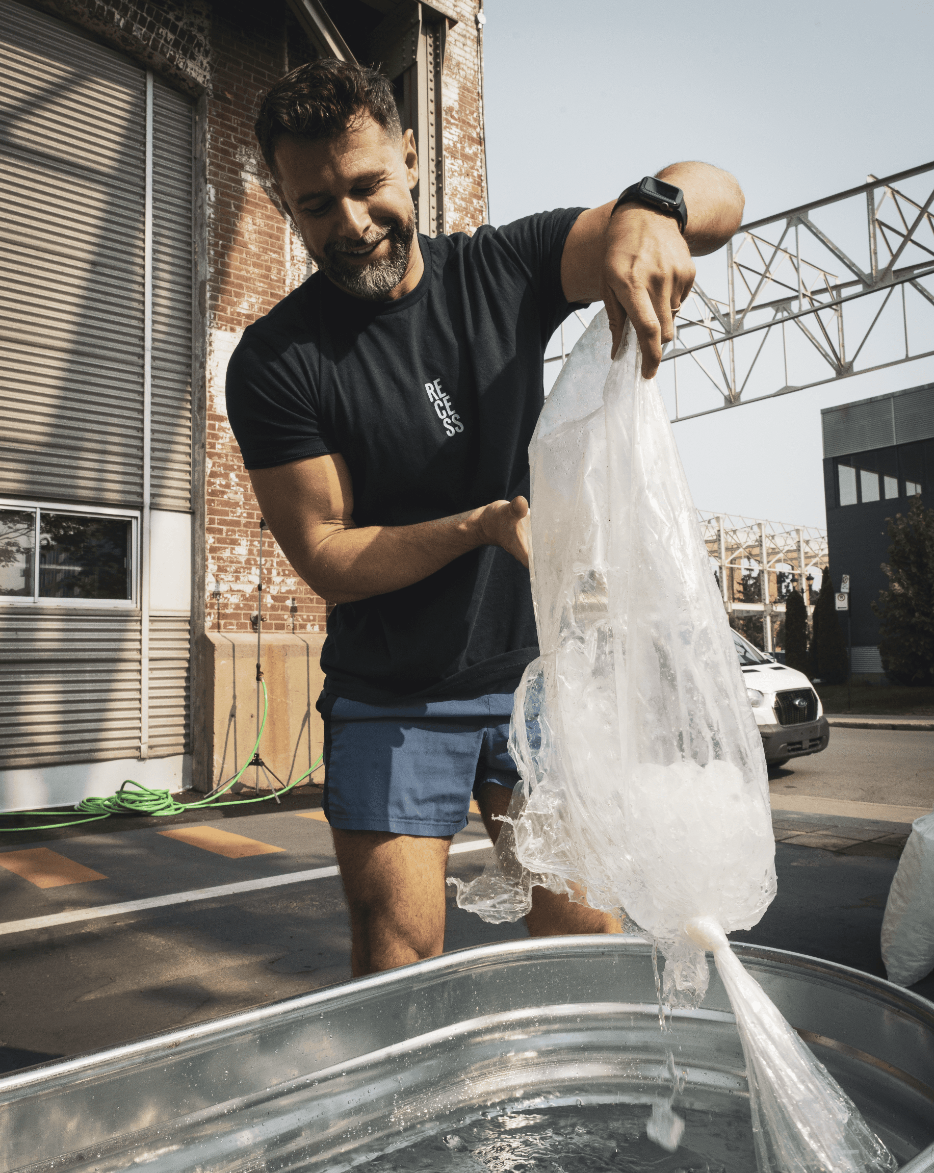 Smiling individuals wearing RECESS shirts pose together indoors, suggesting a casual and joyful moment.