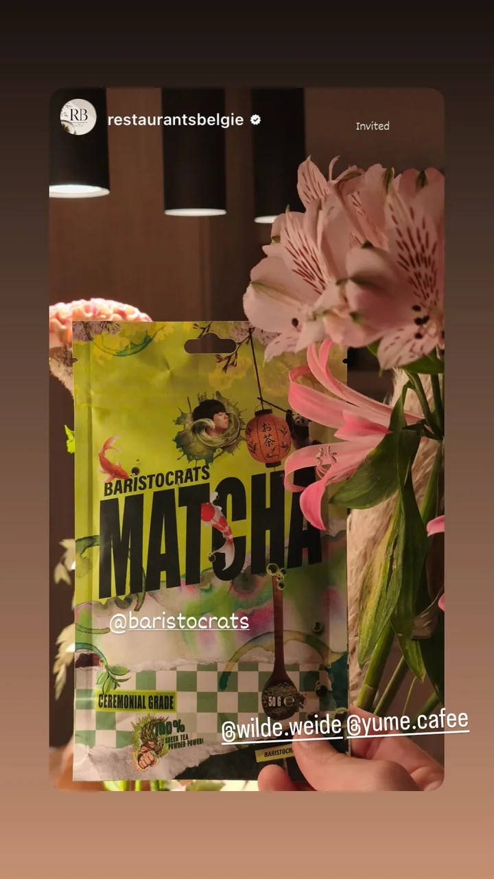 Baristocrats matcha naast roze bloemen.
