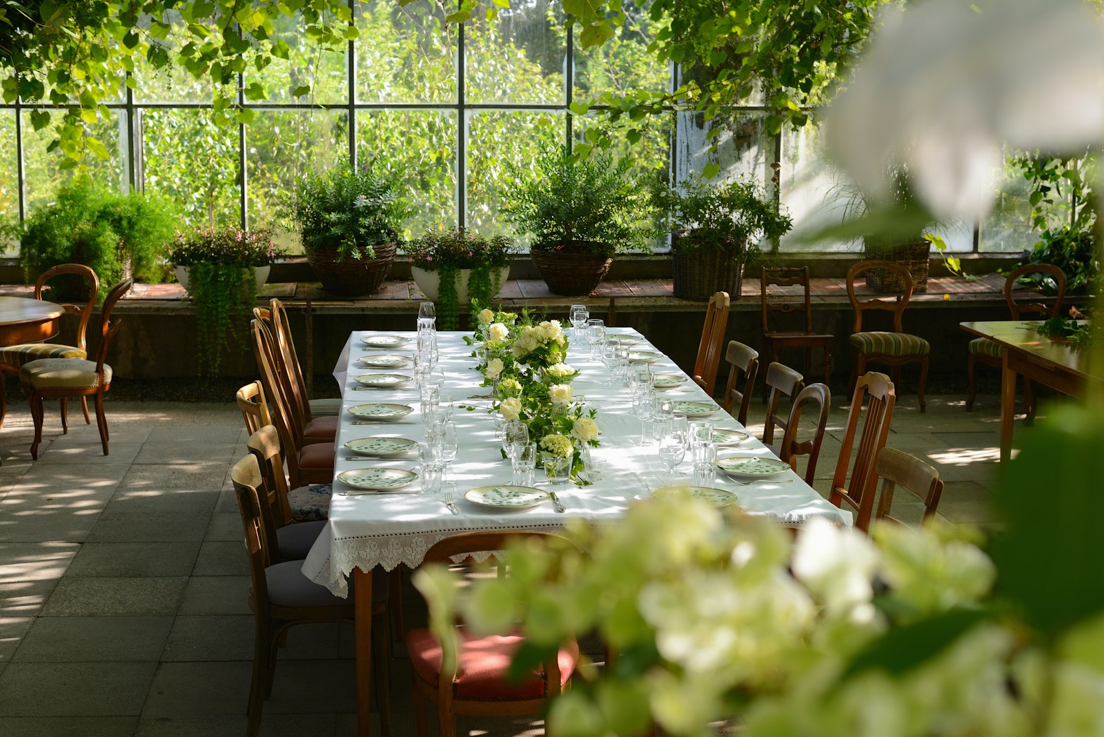 The Glasshouse: a dining room with tables and chairs covered in white tablecloths