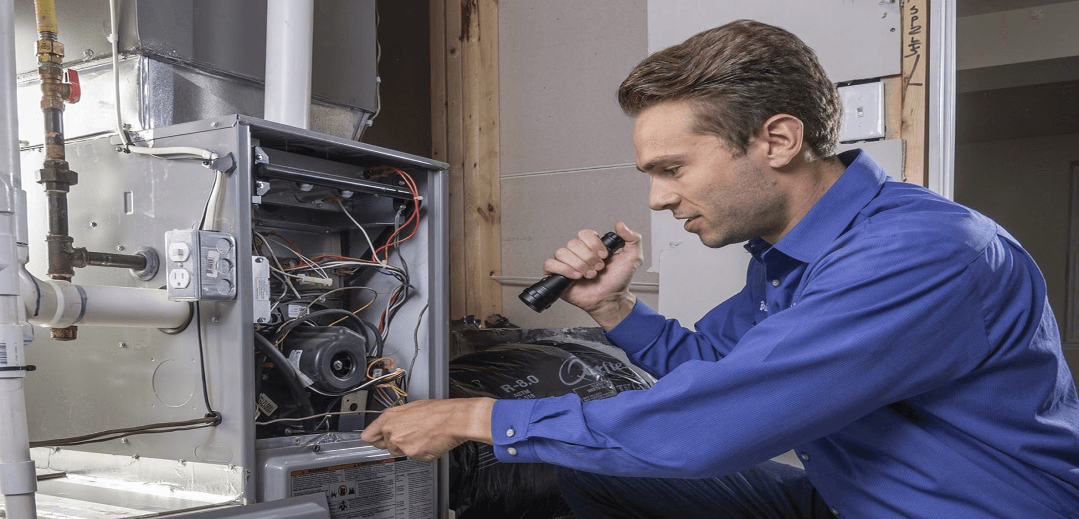 Technician testing furnace electrical components and checking for repair issues.