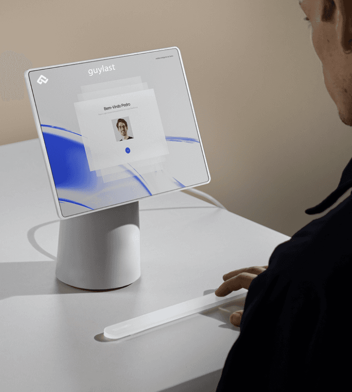 A talent recruiter with a soft smile working on her laptop in the office. The angle is on her face so we can't see what's is on the screen. She is wearing a blazer 