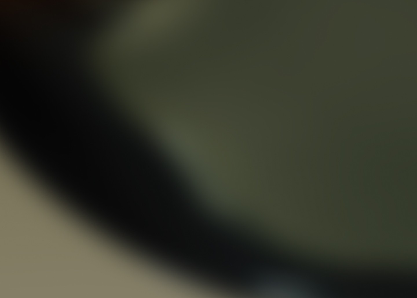 Nahaufnahme einer abstrakten, gläsernen Oberfläche mit sanften Kurven und einem verschwommenen Hintergrund.