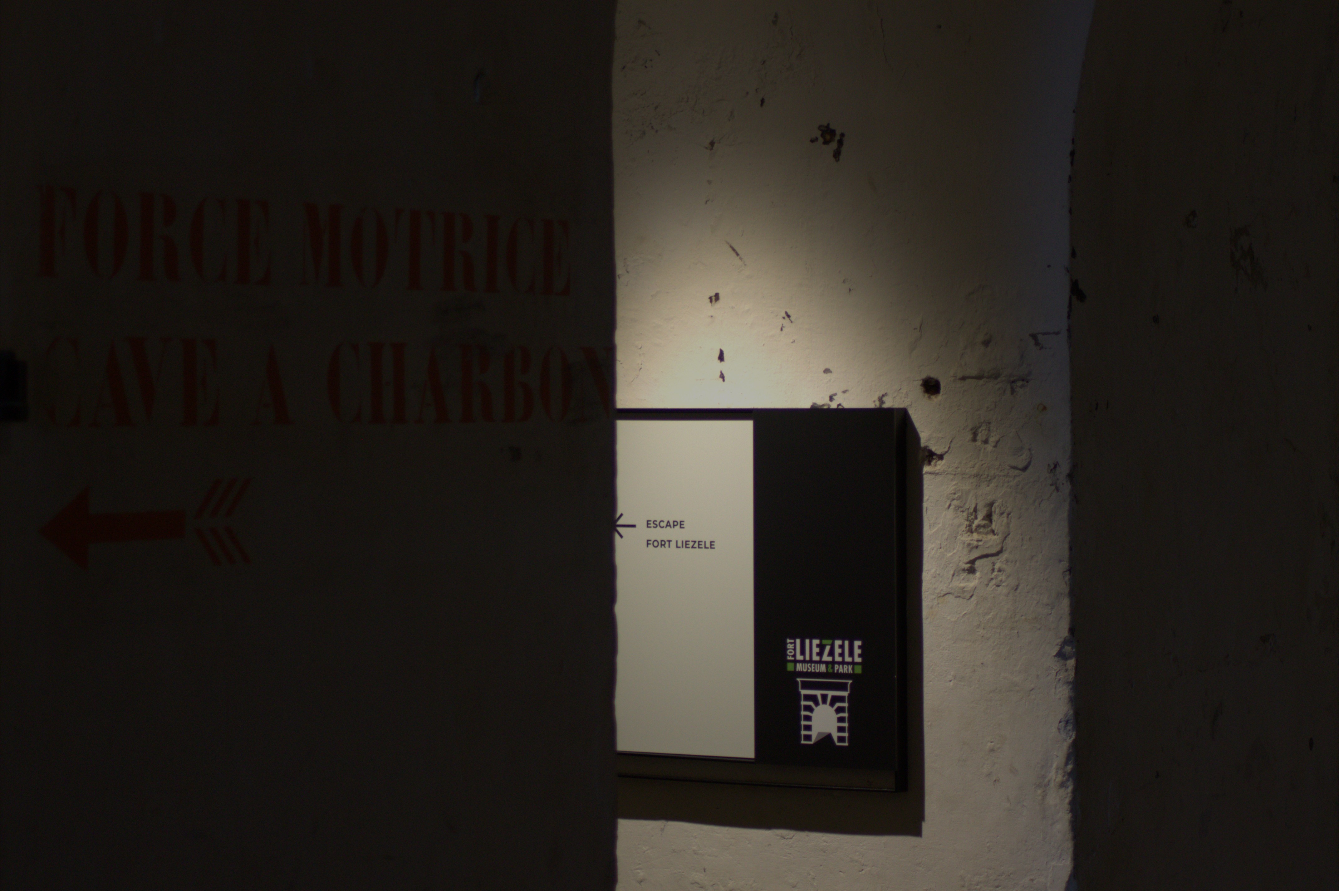 Escape Fort Liezele: donkere mysterieuze gang met bakstenen muren en dim verlichting – spannende corridor in authentiek fort Puurs Antwerpen escape room