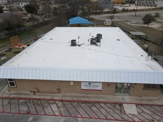 White TPO commercial roof with rooftop equipment and metal perimeter