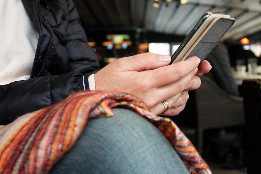 person in black jacket holding black smartphone