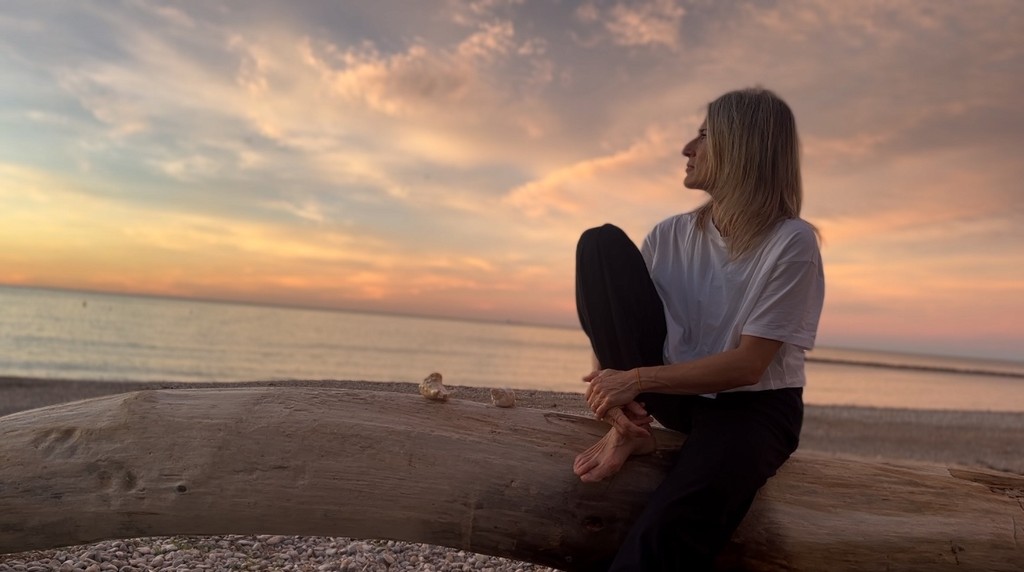 mujer sentada admirando el atardecer